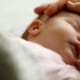 KISS-Syndrom bei Babys: Symptome, Diagnose und sanfte Therapien für dein Kind 5 Hand der Mutter, die den Kopf ihres Babys streichelt