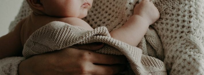 Baby Hautausschlag - das Baby wird von der Mutter gehalten