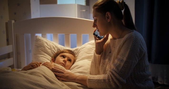 Mutter ruft nachts den &auml;rztlichen Bereitschaftsdienst am Bett ihres kranken Kindes an