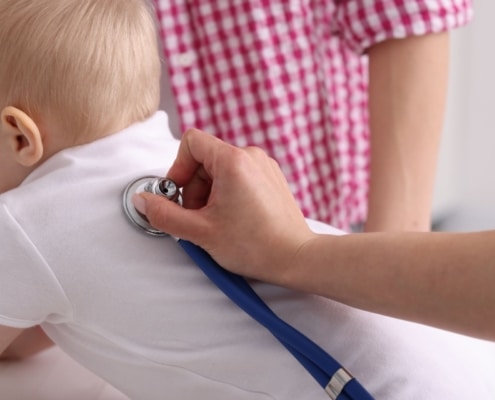 Kinder&auml;rztin h&ouml;rt ein Baby mit dem Stethoskop ab
